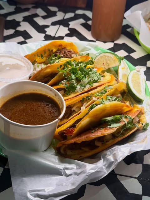 El Poco birria tacos served with a cup of consommé